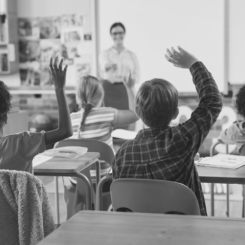 Kinder melden sich im Unterricht