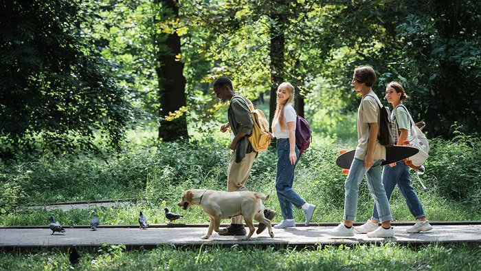 Jugendliche laufen lachend durch einen Park