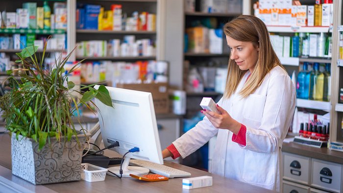 Apothekerin schaut auf Computer
