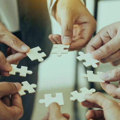 Hände halten Puzzlestücke