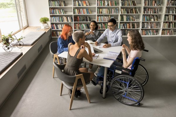 fünf junge Personen sitzen um einen Tisch